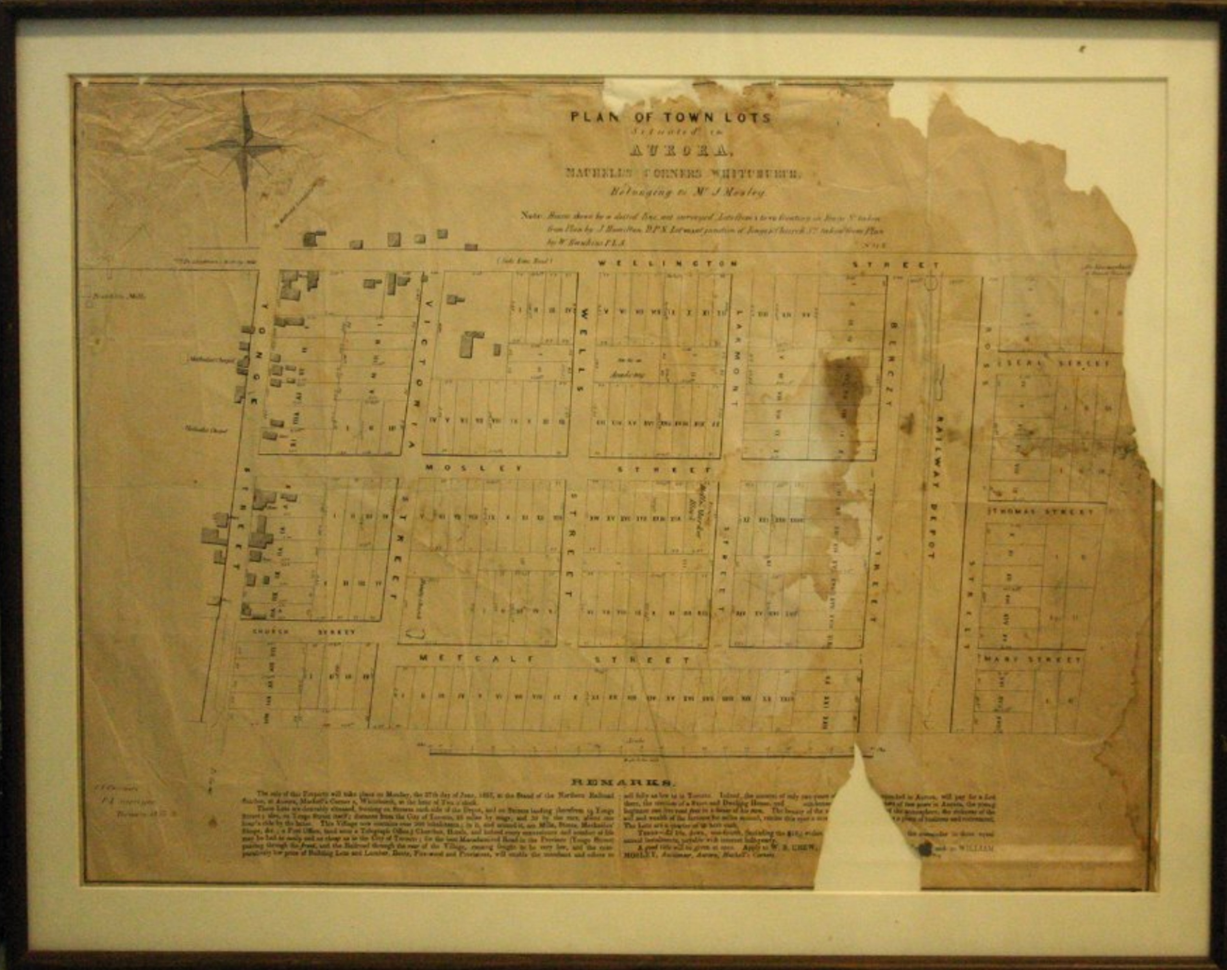 A yellowed and torn map a a town street and lot plan.