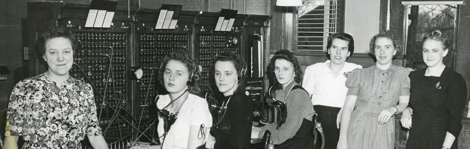 Black and white photo of women working at a telephone switchboard.