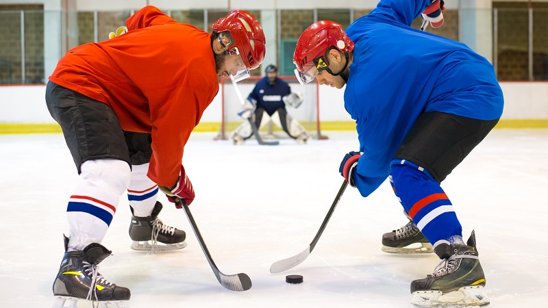 Two adults playing shinny hockey