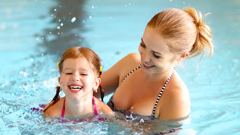 Mom and daughter swimming indoor pool