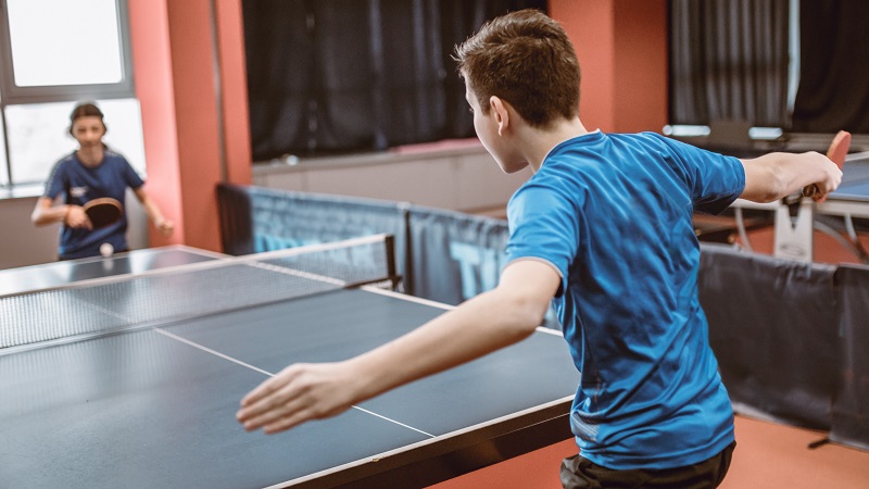 Two youth teens playing table tennis