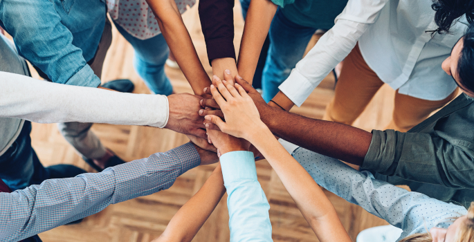 Group of hands meeting in middle of circle