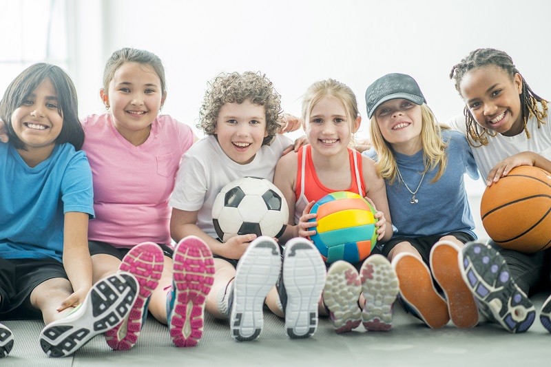 Group of kids with balls in gym