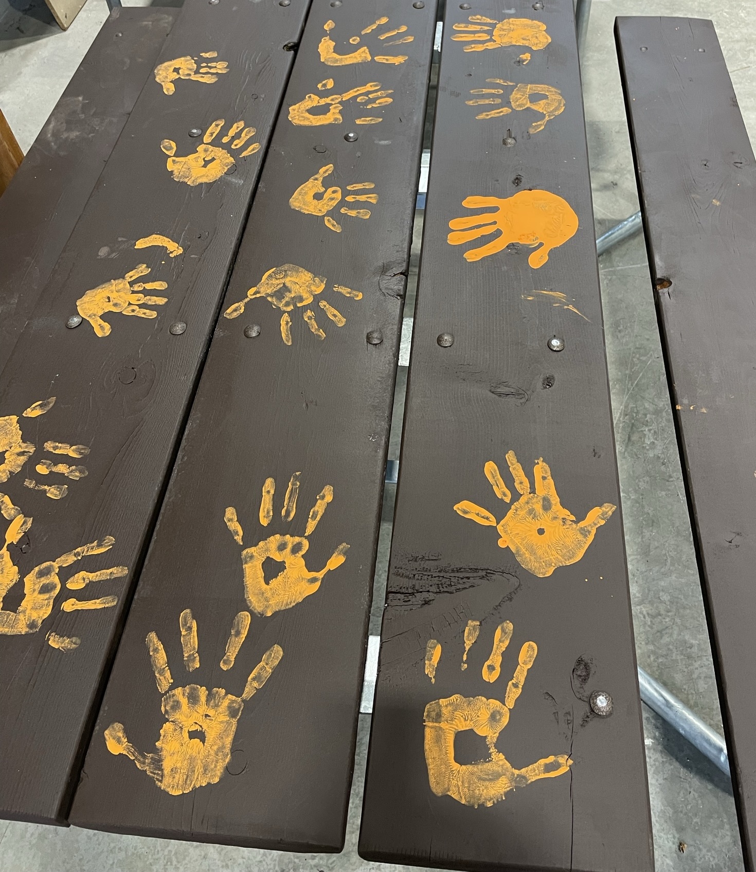 Picnic table with orange handprints