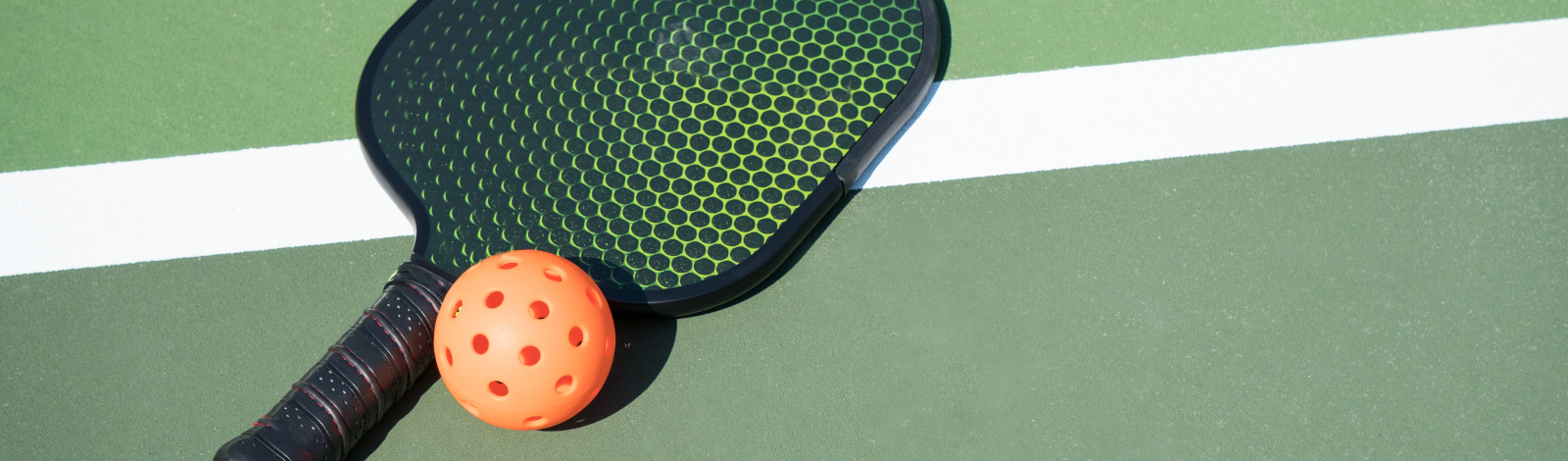 Pickleball and paddle on court