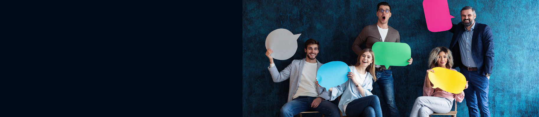 Five smiling people sitting and standing with coloured empty message bubbles in their hands