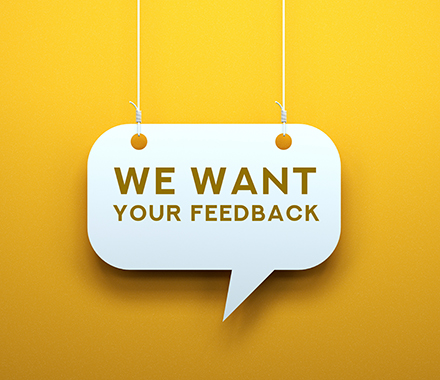 Speech bubble on a yellow background, with the words "We want your feedback"