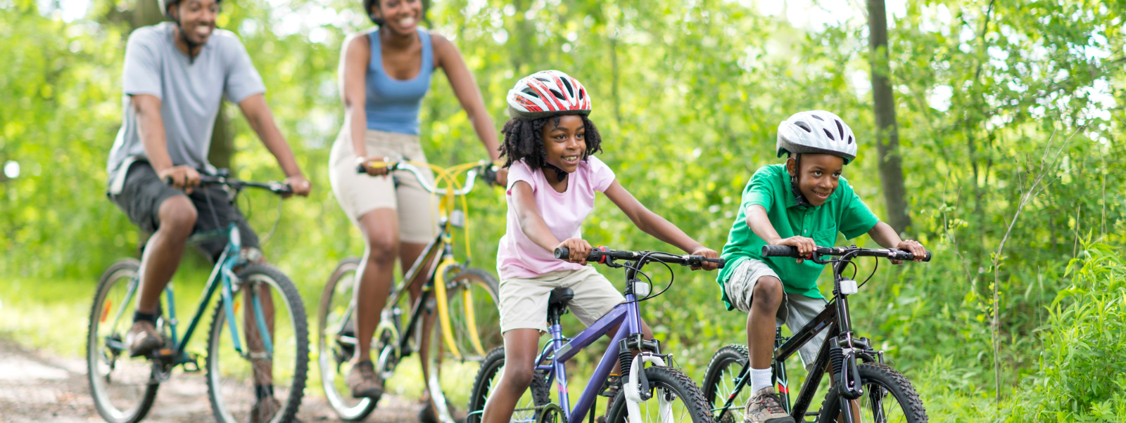 Kids riding their bike with parents behind them