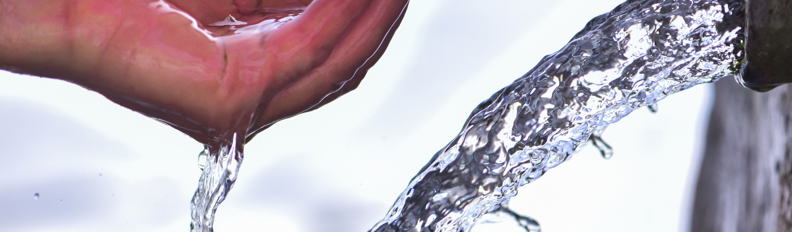 water coming out of pipe with a hand holding water