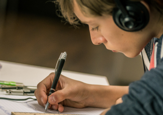 Child listening to music and writing