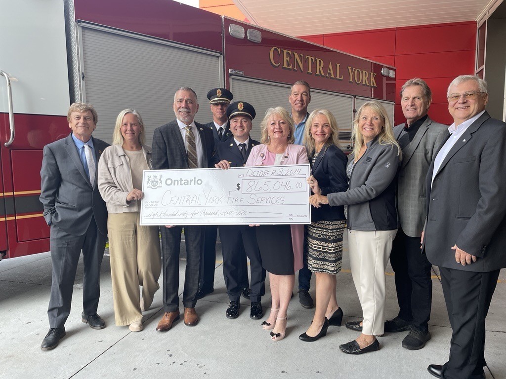 MPP Dawn Gallagher Murphy, Fire Chief Rocco Volpe, Assistant Deputy Chief Duval alongside Aurora Mayor Mrakas, Newmarket Mayor Taylor and members of Newmarket and Aurora Council holding up a large cheque