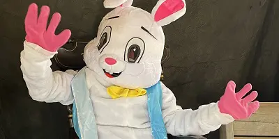 Person wearing Easter Bunny costume waving