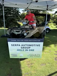 A man under a tent, sitting on an all terrain vehicle