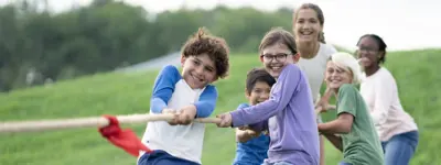 Group of young teens playing tug-of-war in the summer