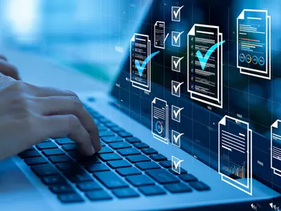 Hands on a laptop keyboard, with digital graphics hovering over the screen. A blue hue over the entire image