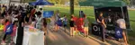 Group of people in park viewing vendors at event