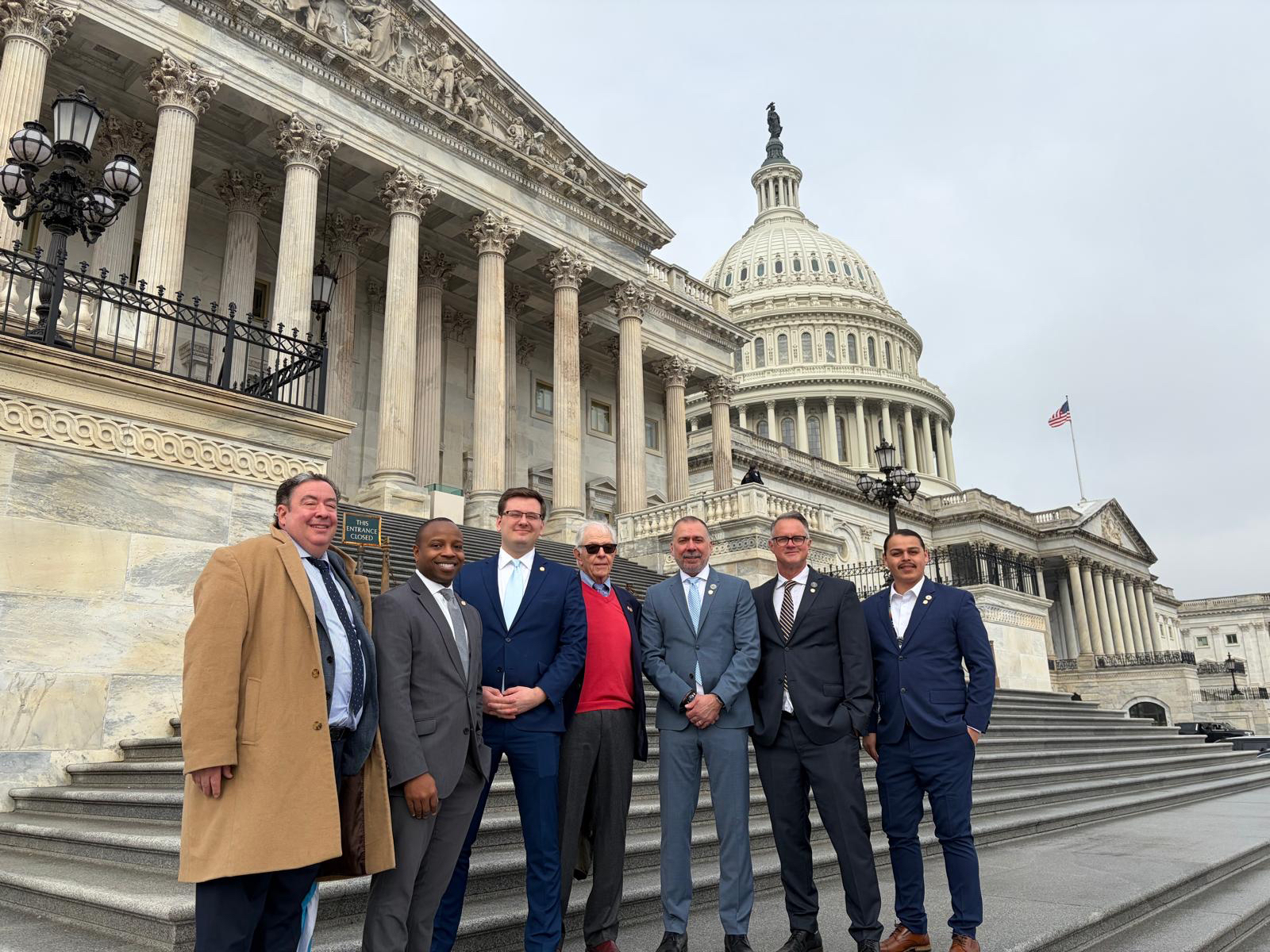 Mayor with a group of people posing for a picture in front of the white house