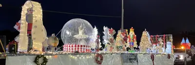 Long trailer decorated with white Christmas trees and snow globes