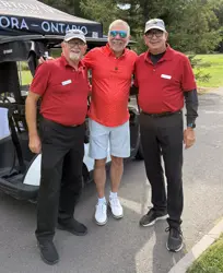 Three men in red shirts side-by-side posing for a picture