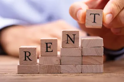 Scrabble pieces that spell out Rent