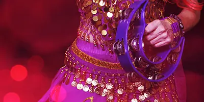 Closeup image of woman dancing with tambourine in hand