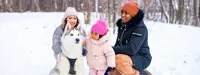 Dad, mom, daughter and dog in winter snow