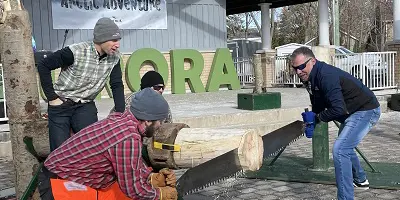 Mayor and two participants large saw and wood