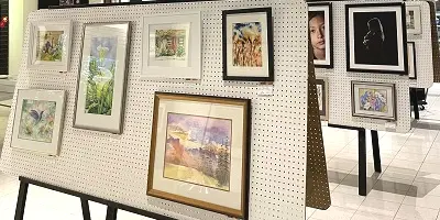 Numerous art pieces displayed on easels