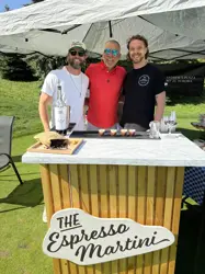 Three men under a tend, behind an espresso martini bar