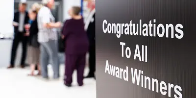 Congratulations to all winner sign with people in the background