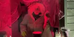 Spooky outdoor cabin in the evening night with red light and man inside
