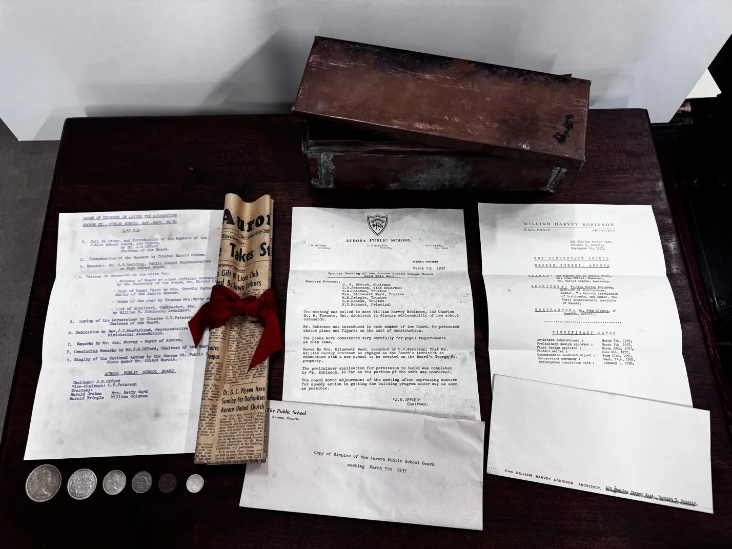 A metal box, scroll, letters and coins