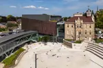 Outdoor space, showing an old school, performance centre and glass bridge