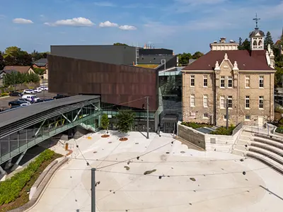 Outdoor space, showing an old school, performance centre and glass bridge