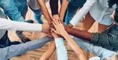 Group of hands meeting in middle of circle