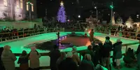 Outdoor ice rink lit up with green lights at night