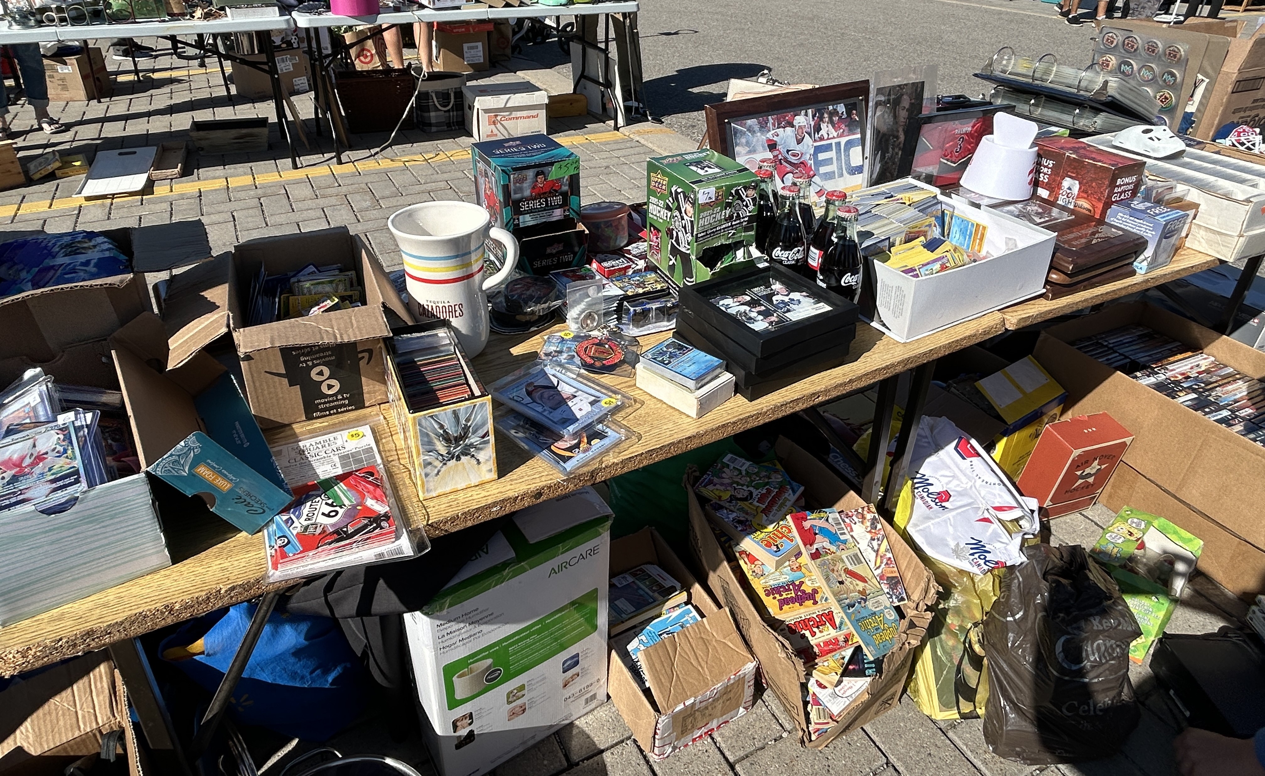 Image of a table at a garage sale with books, housewares and toys