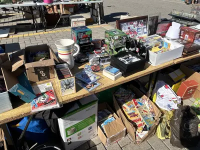 Image of a table at a garage sale with books, housewares and toys