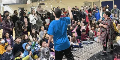Large group of people watching bubble performers