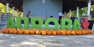 Green AURORA letters in front of band stage with pumpkins